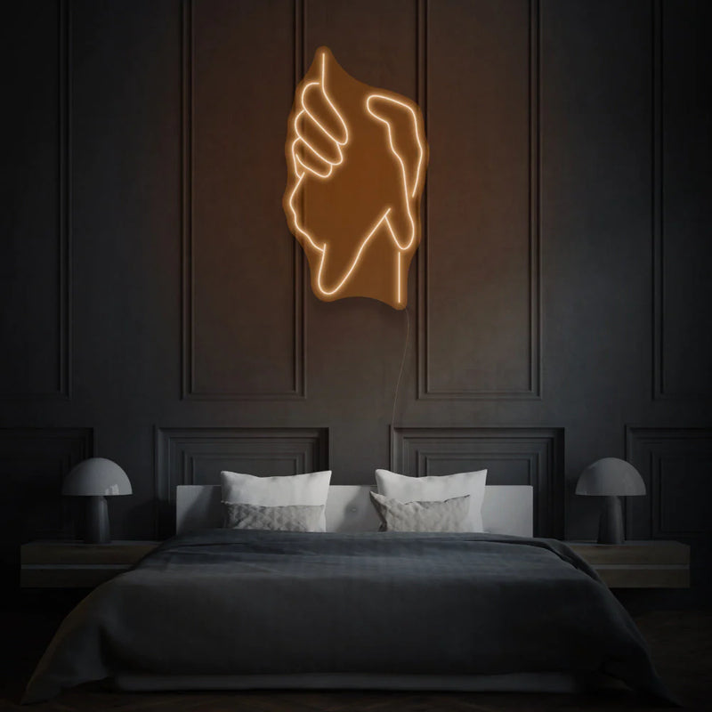 une enseigne Néon Orange LED au design original et artistique représentant deux mains se tenant. Cette enseigne lumineuse est idéale pour une utilisation dans un contexte de décoration néon LED Maroc.